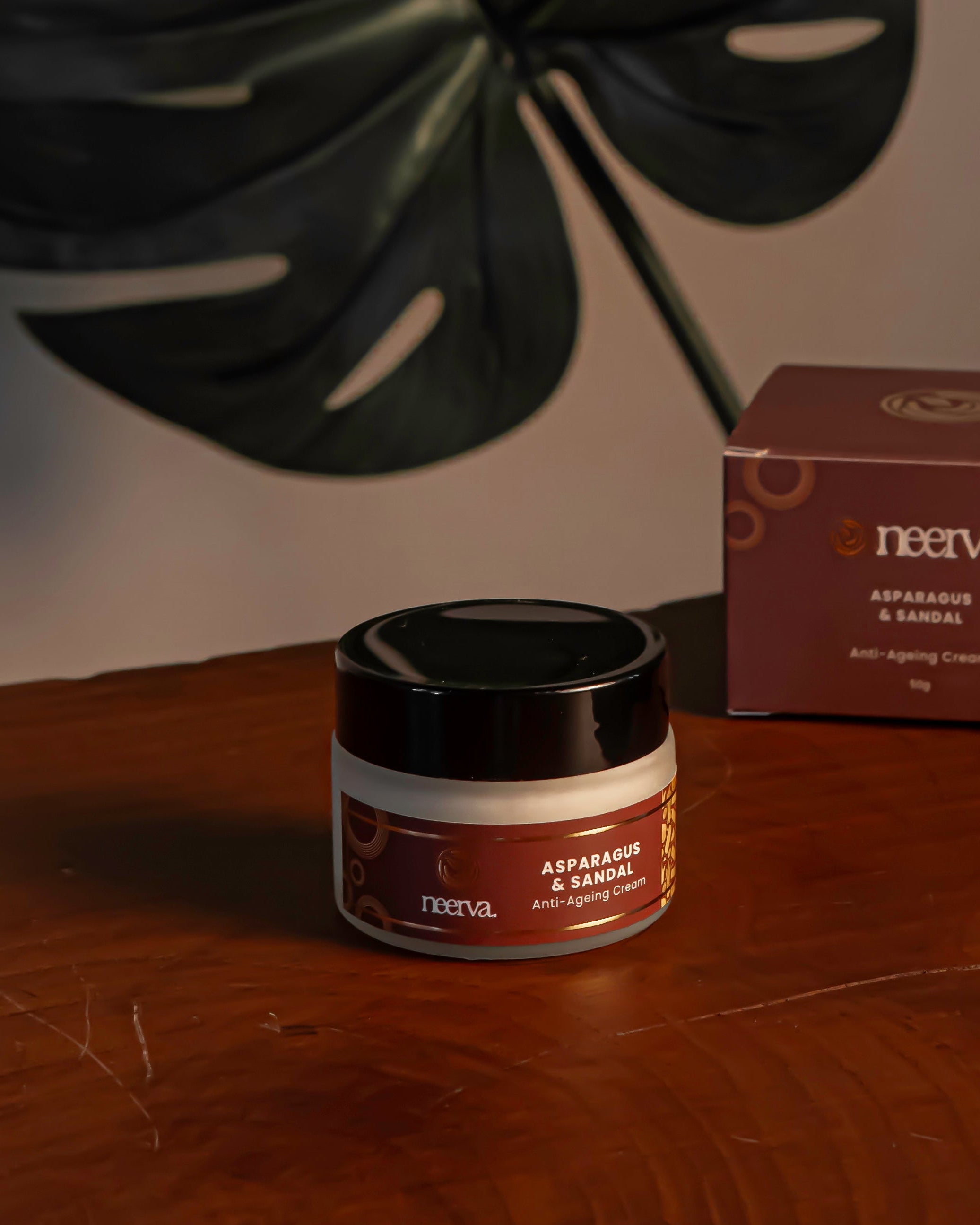 Jar and box of a product on a wooden surface with a leaf in the background